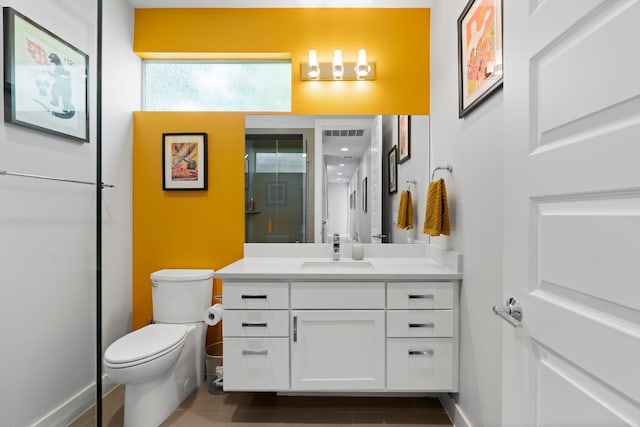bathroom featuring visible vents, toilet, vanity, baseboards, and a stall shower