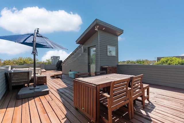 deck with an outdoor hangout area, an outbuilding, and outdoor dining space