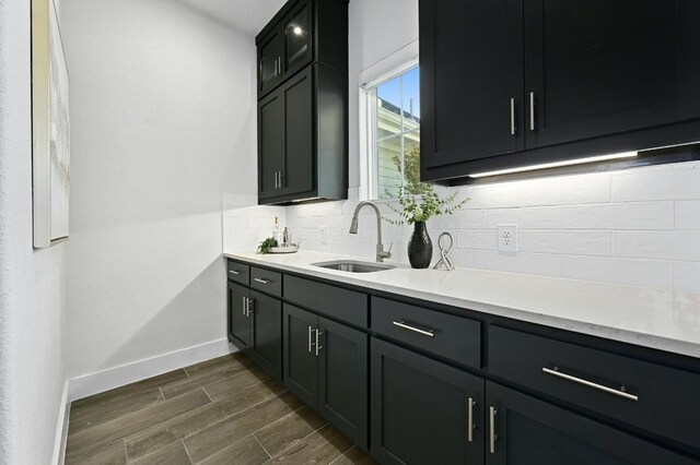 kitchen with tasteful backsplash, sink, and dark wood-type flooring