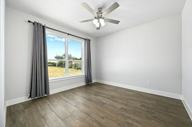 unfurnished room with dark wood-type flooring and ceiling fan