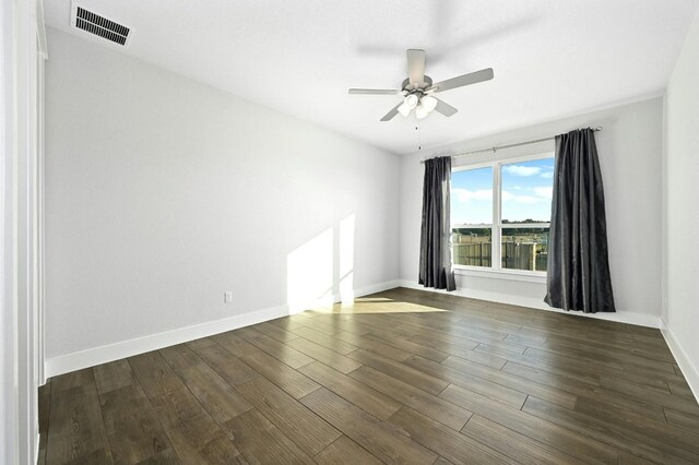 unfurnished room featuring dark wood-type flooring and ceiling fan