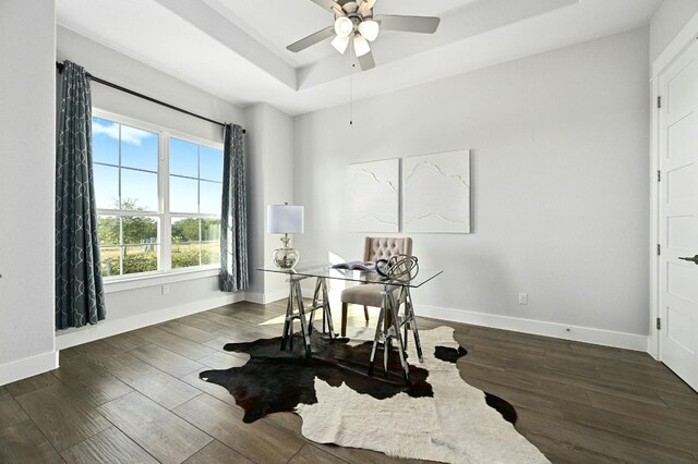 office featuring ceiling fan, a raised ceiling, and dark hardwood / wood-style floors