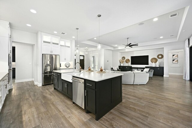 kitchen with a center island with sink, appliances with stainless steel finishes, sink, and white cabinetry