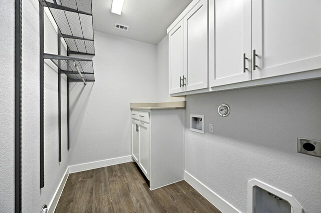 washroom featuring dark wood-type flooring, cabinets, hookup for an electric dryer, and hookup for a washing machine