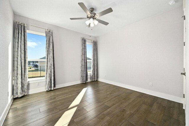 empty room featuring dark wood-type flooring and ceiling fan