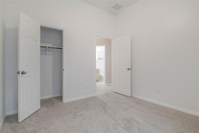 unfurnished bedroom with a closet and light carpet