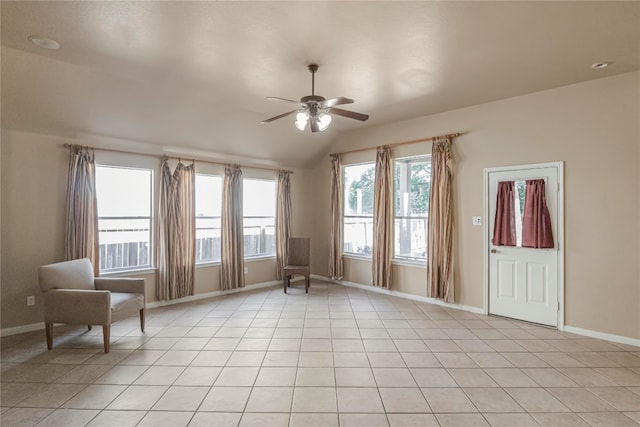 spare room with ceiling fan, light tile patterned floors, plenty of natural light, and vaulted ceiling