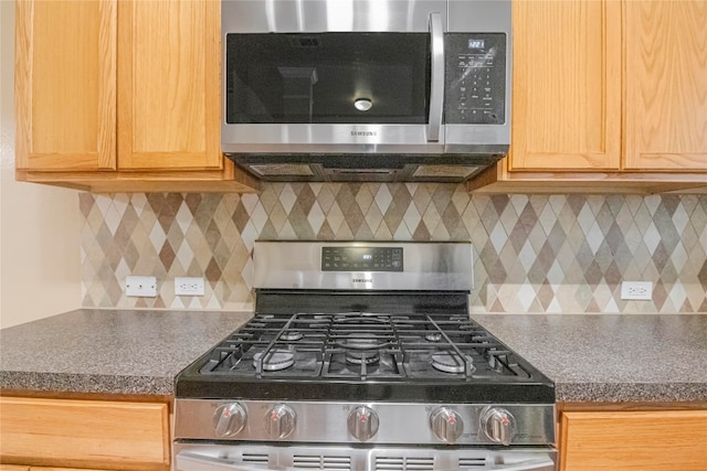 kitchen featuring appliances with stainless steel finishes and decorative backsplash