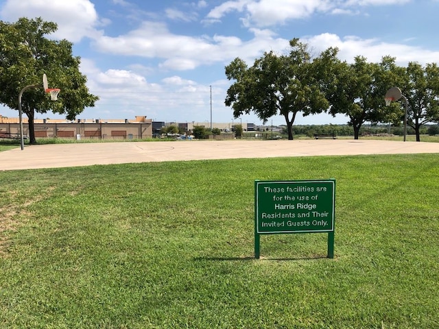 view of home's community featuring a yard and basketball court