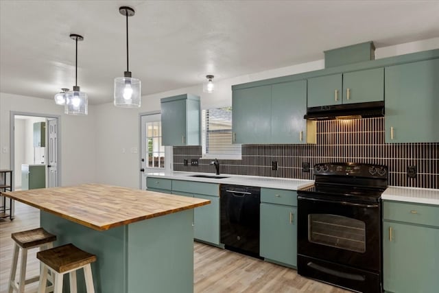 kitchen featuring green cabinetry, black appliances, decorative backsplash, and a kitchen island