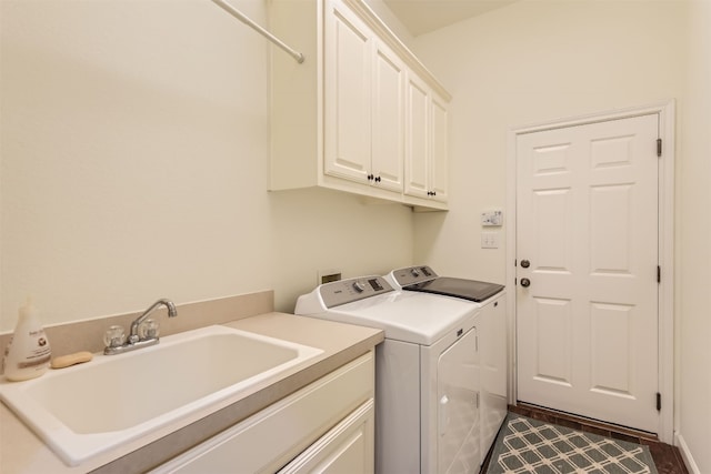 clothes washing area featuring cabinets, sink, washer and dryer, and dark hardwood / wood-style floors