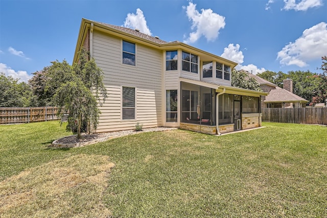 back of property with a sunroom and a yard