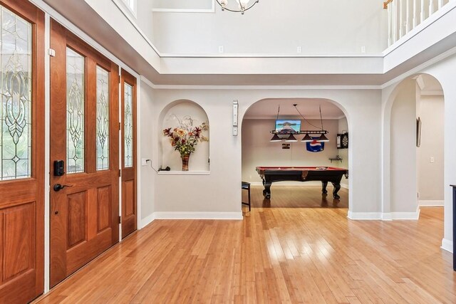 foyer entrance featuring crown molding, wood-type flooring, and plenty of natural light