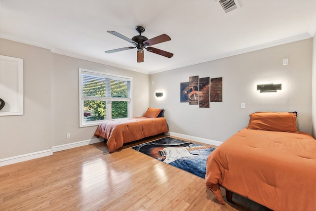 bedroom with crown molding, hardwood / wood-style floors, and ceiling fan