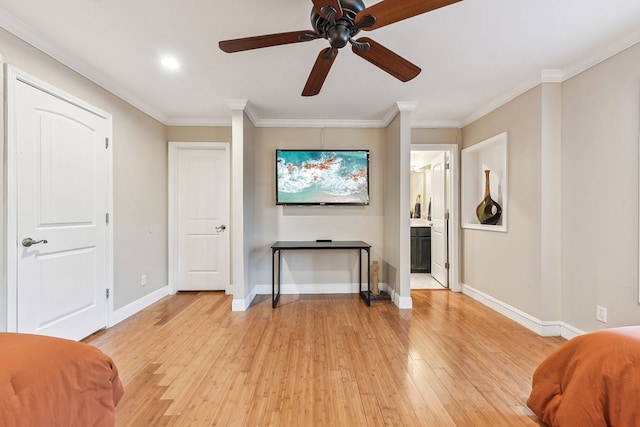 interior space with ensuite bath, crown molding, light wood-type flooring, and ceiling fan