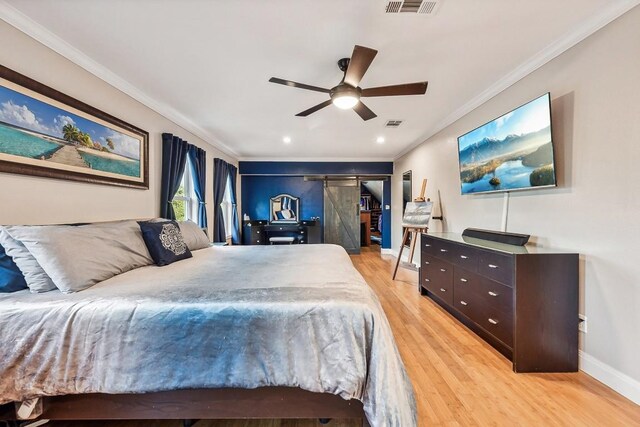 bedroom with ceiling fan, crown molding, light hardwood / wood-style flooring, and a barn door