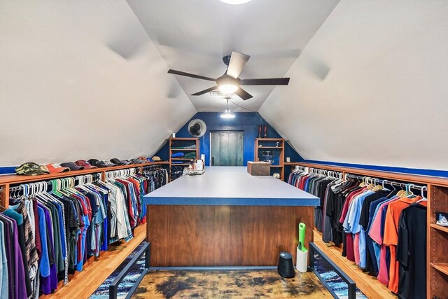 spacious closet featuring lofted ceiling, wood-type flooring, and ceiling fan