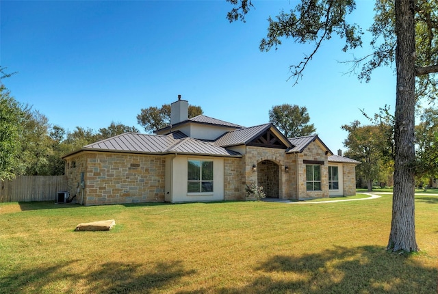 ranch-style house with central air condition unit and a front lawn