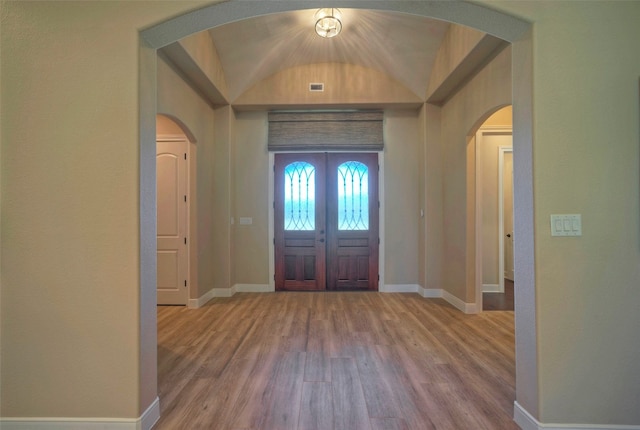 foyer entrance with lofted ceiling and hardwood / wood-style floors