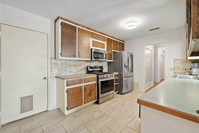 kitchen featuring backsplash, sink, and stainless steel appliances