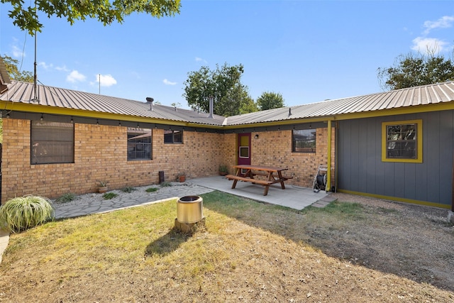 back of property featuring a yard and a patio