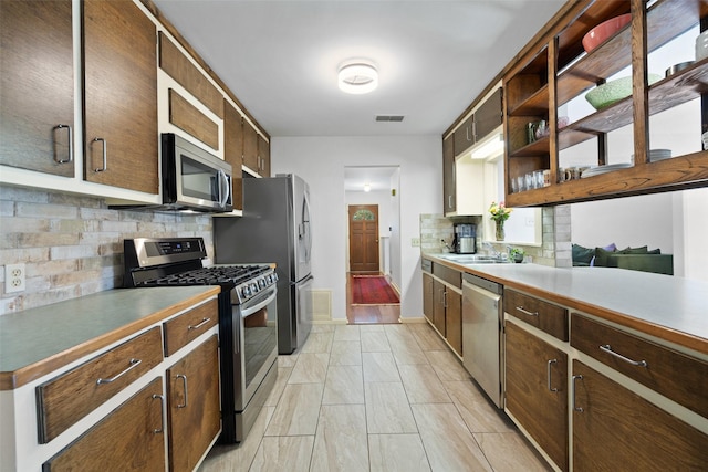 kitchen with decorative backsplash, sink, and appliances with stainless steel finishes