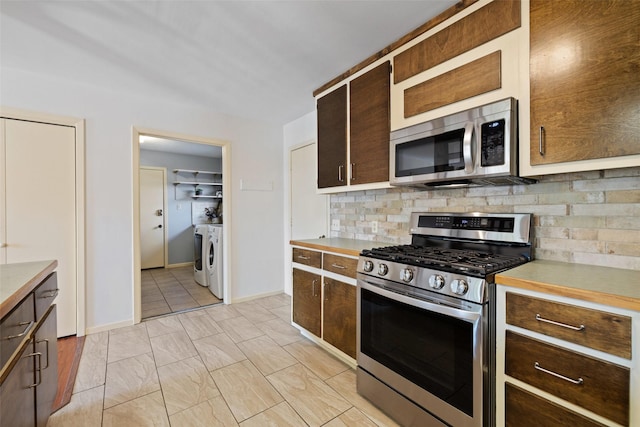 kitchen with backsplash, separate washer and dryer, and stainless steel appliances