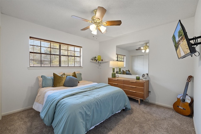 carpeted bedroom with ceiling fan and a textured ceiling