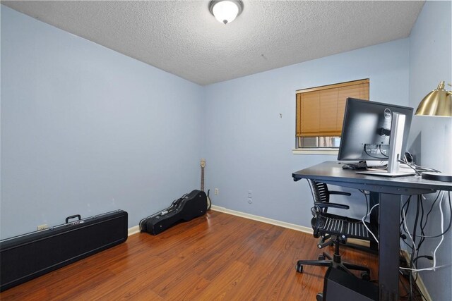 home office with wood-type flooring and a textured ceiling