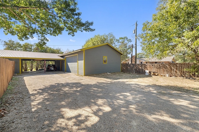 view of property exterior featuring a carport, a garage, and an outbuilding