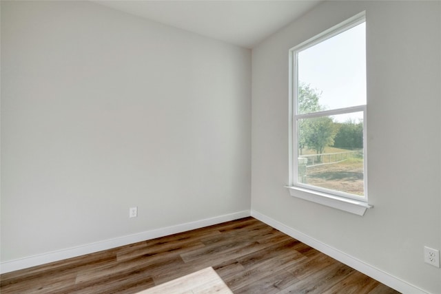 spare room with hardwood / wood-style flooring and a wealth of natural light