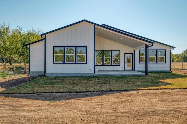 rear view of house featuring a patio area and a yard