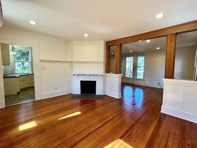 314 Pershing Ave, San Antonio, TX 78209 - unfurnished living room featuring plenty of natural light, a fireplace, a sink, and wood finished floors