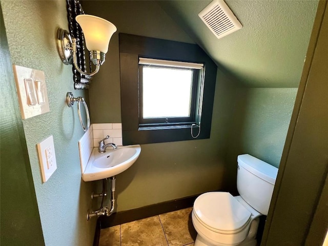 314 Pershing Ave, San Antonio, TX 78209 - bathroom with a textured wall, tile patterned floors, toilet, visible vents, and lofted ceiling
