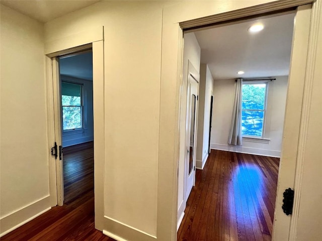 hallway with baseboards, dark wood-type flooring, recessed lighting, and a healthy amount of sunlight