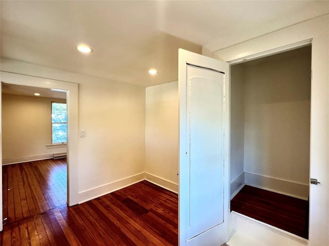 empty room featuring hardwood / wood-style floors, recessed lighting, and baseboards