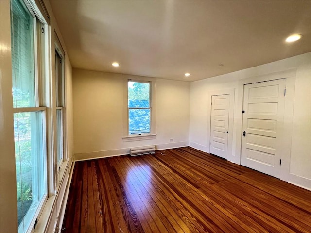 unfurnished room with baseboards, dark wood finished floors, and recessed lighting