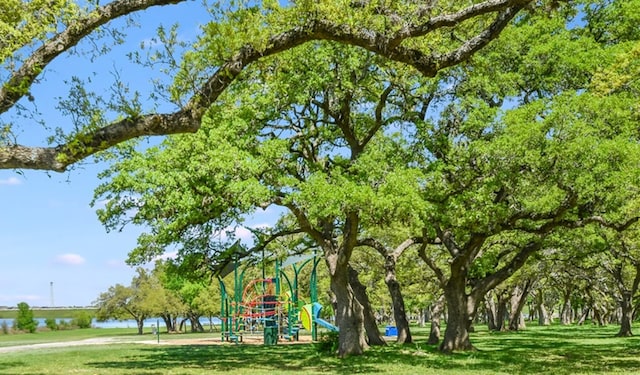 view of community with a lawn, a water view, and a playground