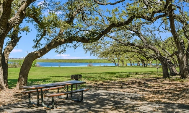 view of community with a water view and a lawn