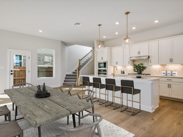 dining area with sink and light hardwood / wood-style flooring