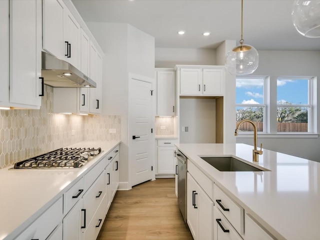 kitchen with white cabinets, decorative light fixtures, sink, and stainless steel appliances