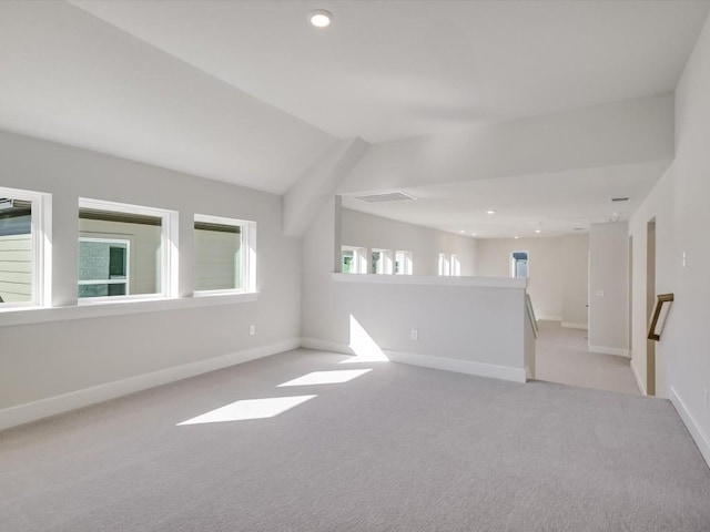 unfurnished room with light colored carpet and lofted ceiling