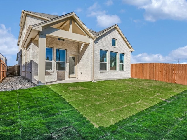 back of property featuring a lawn and a patio