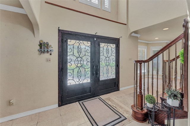 foyer with ornamental molding, french doors, and light tile patterned floors