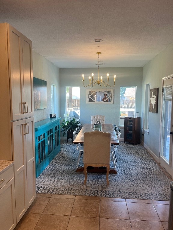 dining room with a textured ceiling, tile patterned floors, a chandelier, and plenty of natural light