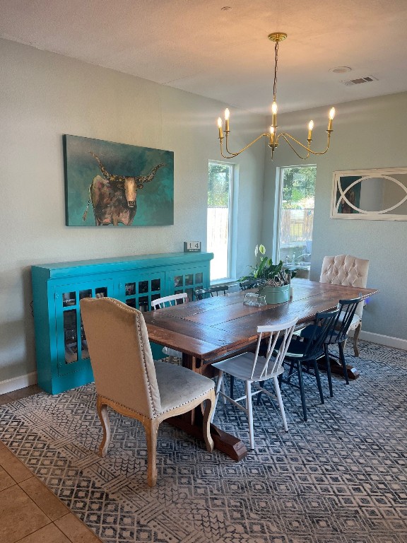 carpeted dining area with a notable chandelier