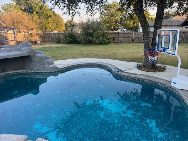 view of pool with a lawn