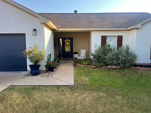 entrance to property featuring a garage and a lawn