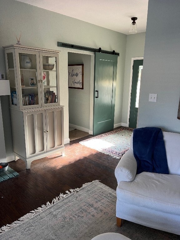 living room featuring a barn door and dark hardwood / wood-style flooring