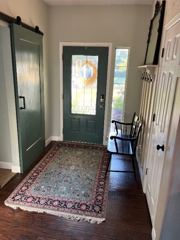 entryway featuring a barn door and dark wood-type flooring